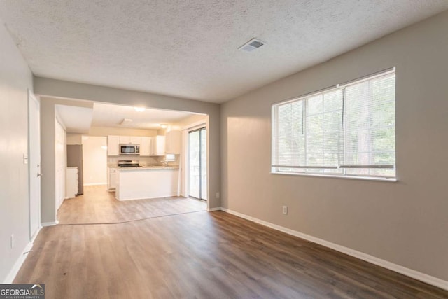 5092 Stone Trce, Stone Mountain, GA 30083 - unfurnished living room featuring light wood-style flooring, baseboards, and a textured ceiling