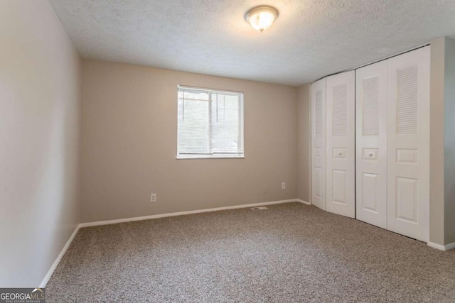 5092 Stone Trce, Stone Mountain, GA 30083 - unfurnished bedroom featuring carpet, a textured ceiling, a closet, and baseboards