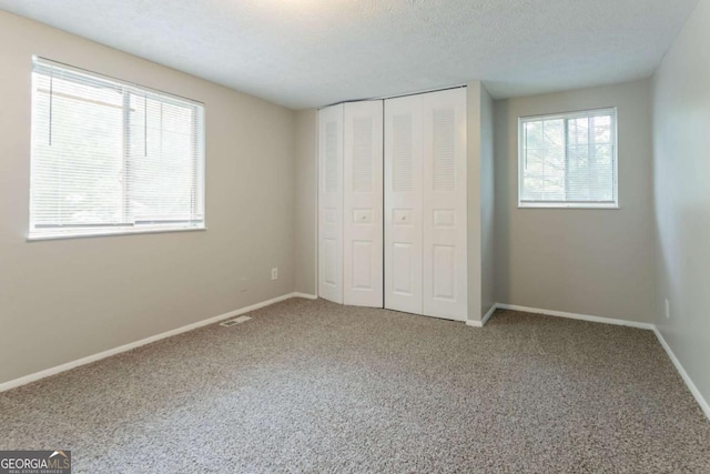 5092 Stone Trce, Stone Mountain, GA 30083 - unfurnished bedroom featuring multiple windows, carpet, a closet, and baseboards