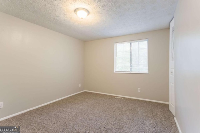 5092 Stone Trce, Stone Mountain, GA 30083 - spare room featuring carpet flooring, a textured ceiling, and baseboards