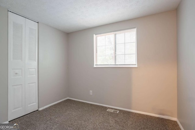 5092 Stone Trce, Stone Mountain, GA 30083 - unfurnished bedroom featuring carpet, a closet, baseboards, and a textured ceiling