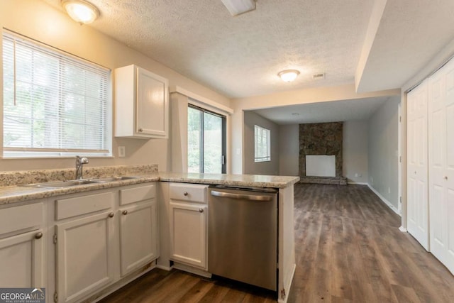 5092 Stone Trce, Stone Mountain, GA 30083 - kitchen featuring stainless steel dishwasher, a sink, a textured ceiling, a fireplace, and a peninsula