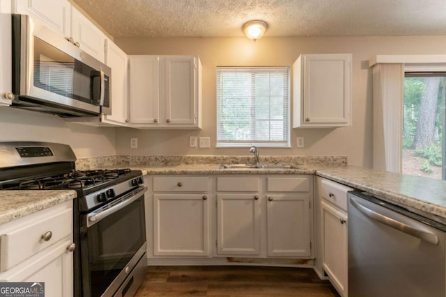 5092 Stone Trce, Stone Mountain, GA 30083 - kitchen with stainless steel appliances, a sink, white cabinetry, light countertops, and dark wood-type flooring