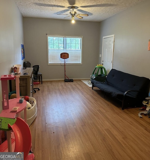 517 Pebble Pt, Loganville, GA 30052 - rec room with wood finished floors, a ceiling fan, a textured ceiling, and baseboards