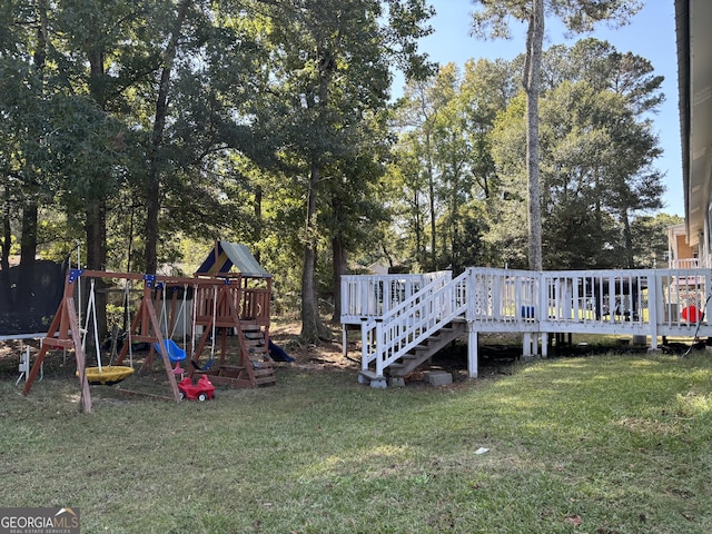 517 Pebble Pt, Loganville, GA 30052 - view of green lawn with a playground, a wooden deck, and view of scattered trees