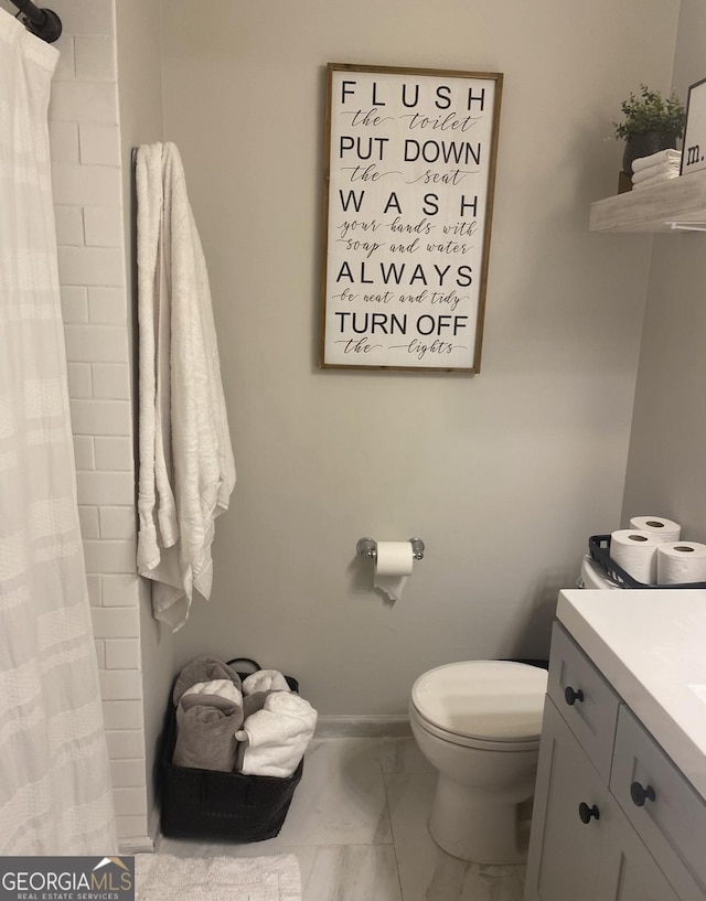 517 Pebble Pt, Loganville, GA 30052 - full bath featuring marble look tile flooring, toilet, vanity, baseboards, and a shower with shower curtain