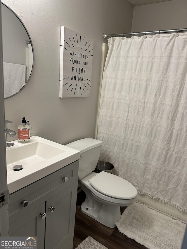 517 Pebble Pt, Loganville, GA 30052 - bathroom with wood finished floors, vanity, toilet, and a shower with shower curtain