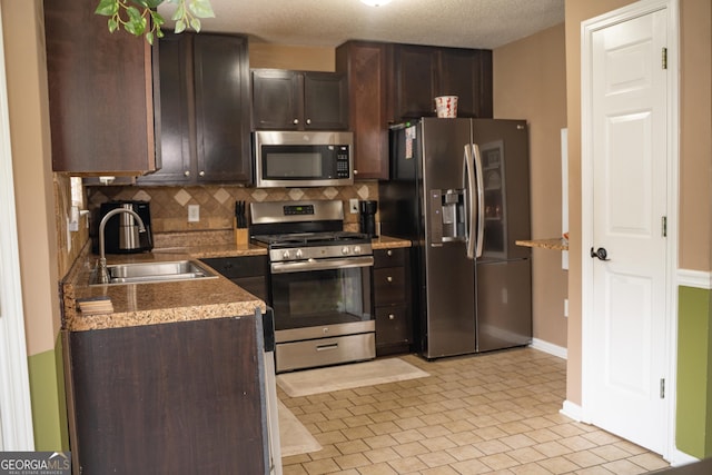 3269 N Winds Trl, Douglasville, GA 30135 - kitchen featuring appliances with stainless steel finishes, a sink, dark brown cabinetry, and decorative backsplash