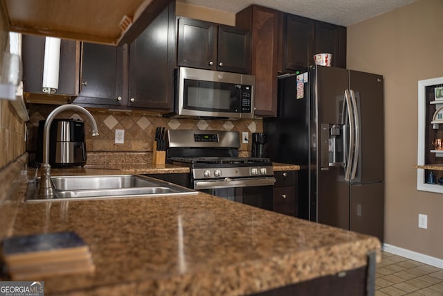 3269 N Winds Trl, Douglasville, GA 30135 - kitchen featuring appliances with stainless steel finishes, a sink, decorative backsplash, light tile patterned floors, and baseboards
