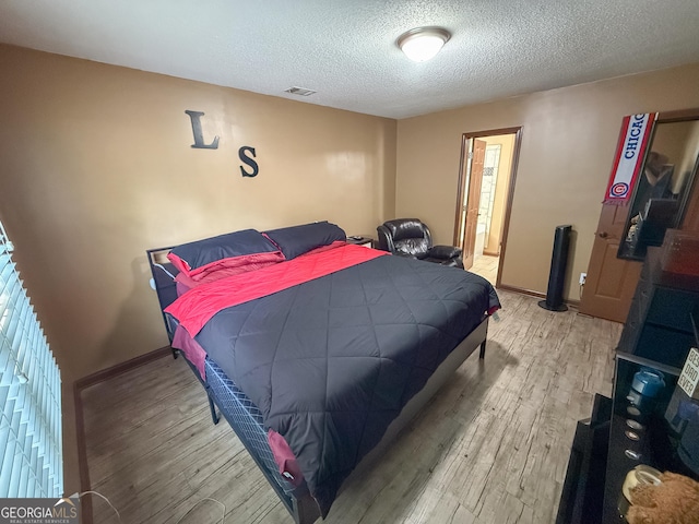 3269 N Winds Trl, Douglasville, GA 30135 - bedroom featuring light wood finished floors, a textured ceiling, and baseboards