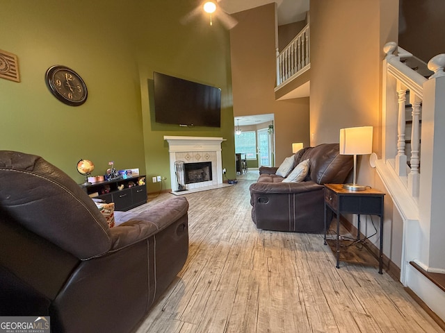3269 N Winds Trl, Douglasville, GA 30135 - living room with wood finished floors, a towering ceiling, stairway, a tile fireplace, and a ceiling fan