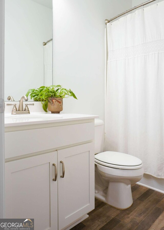 1279 Day Dr, Bogart, GA 30622 - bathroom with vanity, toilet, wood finished floors, and a shower with curtain