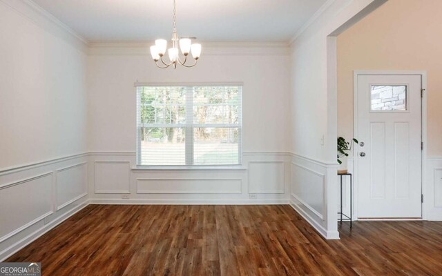 1279 Day Dr, Bogart, GA 30622 - unfurnished dining area featuring a chandelier, dark wood-type flooring, wainscoting, crown molding, and a decorative wall