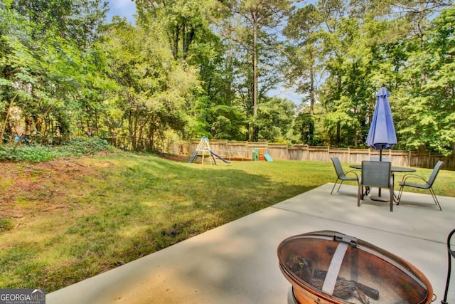 4794 Glenbonnie Ct, Dunwoody, GA 30360 - view of yard with a playground, a patio, an outdoor fire pit, view of wooded area, and outdoor dining space