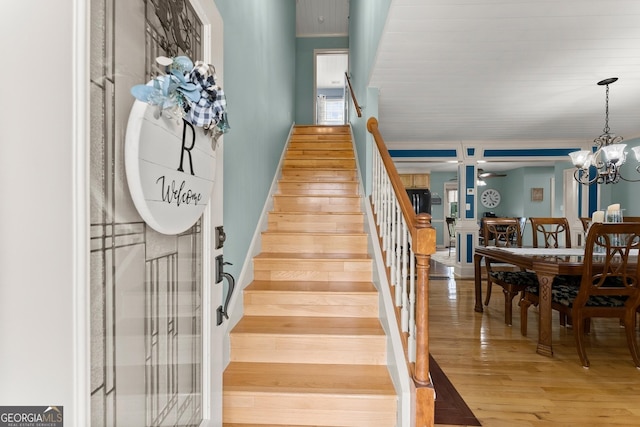 8958 Bill Savage Rd, Lula, GA 30554 - staircase featuring wood finished floors and a chandelier