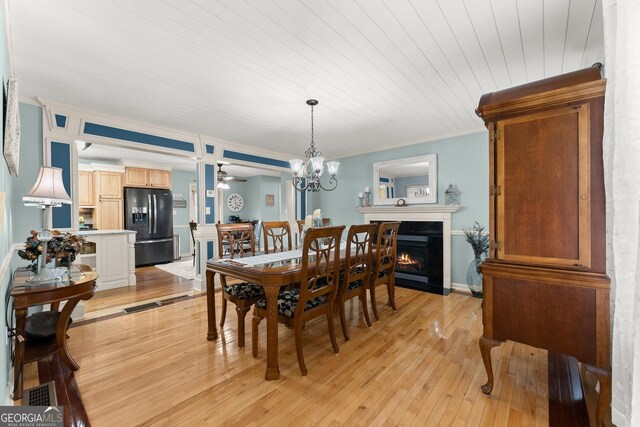 8958 Bill Savage Rd, Lula, GA 30554 - dining room featuring light wood-type flooring, a fireplace with flush hearth, crown molding, a chandelier, and a ceiling fan