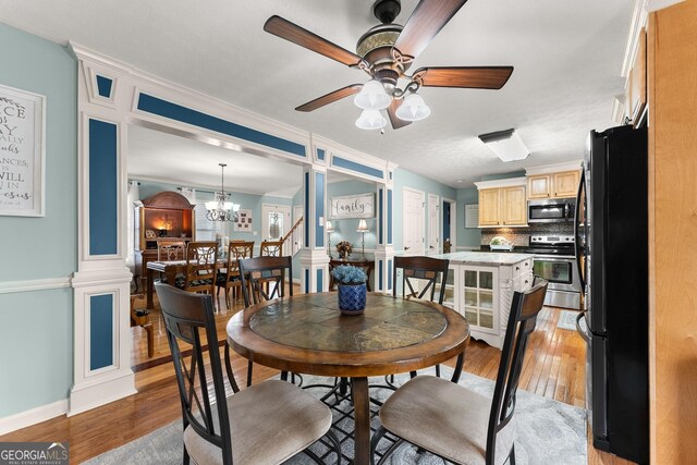 8958 Bill Savage Rd, Lula, GA 30554 - dining area with light wood-style floors, a ceiling fan, a chandelier, and baseboards