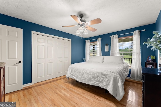 8958 Bill Savage Rd, Lula, GA 30554 - bedroom featuring hardwood / wood-style floors, a closet, a textured ceiling, a ceiling fan, and baseboards