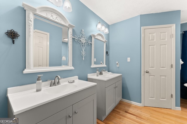 8958 Bill Savage Rd, Lula, GA 30554 - bathroom featuring two vanities, wood finished floors, and baseboards