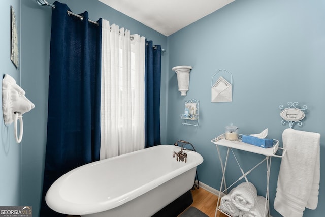 8958 Bill Savage Rd, Lula, GA 30554 - bathroom with wood finished floors, a freestanding bath, and baseboards