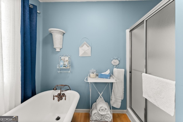 8958 Bill Savage Rd, Lula, GA 30554 - full bath featuring baseboards, a freestanding bath, wood finished floors, and an enclosed shower