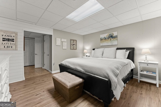 8958 Bill Savage Rd, Lula, GA 30554 - bedroom with a paneled ceiling, light wood-style flooring, and baseboards