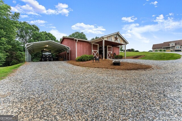 8958 Bill Savage Rd, Lula, GA 30554 - view of front facade with gravel driveway, a carport, a front yard, and an outdoor structure