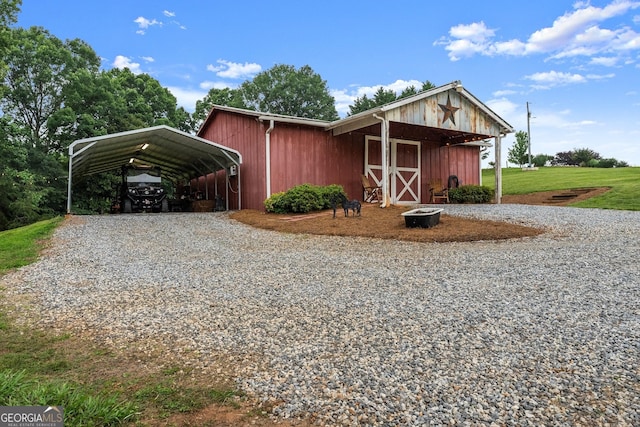 8958 Bill Savage Rd, Lula, GA 30554 - view of front of house with gravel driveway, a detached carport, and an outbuilding