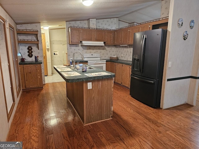 136 Hickory Hl, Anniston, AL 36206 - kitchen featuring black refrigerator with ice dispenser, wood finished floors, a sink, under cabinet range hood, and lofted ceiling