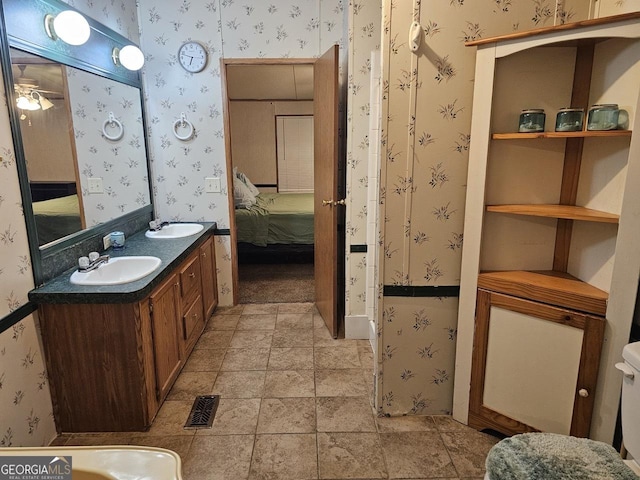 136 Hickory Hl, Anniston, AL 36206 - full bath with connected bathroom, wallpapered walls, double vanity, toilet, and a ceiling fan