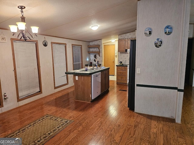 136 Hickory Hl, Anniston, AL 36206 - kitchen with dishwasher, wood finished floors, dark countertops, vaulted ceiling, and an island with sink