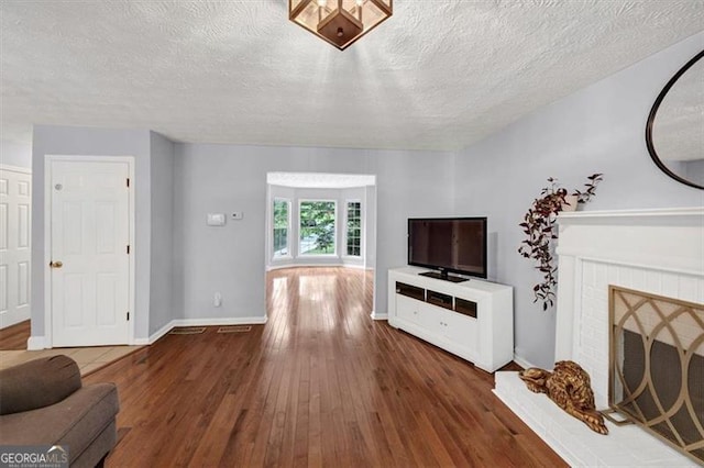 1625 Clark Lake Dr NW, Acworth, GA 30102 - living area with hardwood / wood-style floors, a textured ceiling, a fireplace, and baseboards