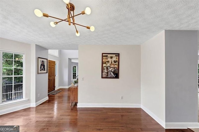 1625 Clark Lake Dr NW, Acworth, GA 30102 - empty room featuring a chandelier, a textured ceiling, wood finished floors, and baseboards