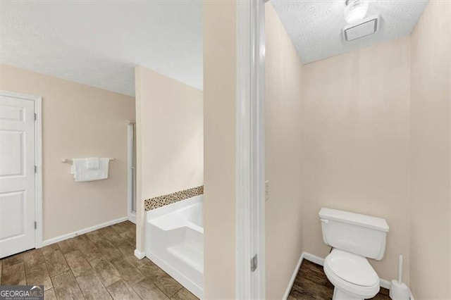 1625 Clark Lake Dr NW, Acworth, GA 30102 - bathroom featuring a garden tub, toilet, wood finished floors, and baseboards