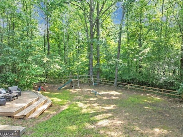 1625 Clark Lake Dr NW, Acworth, GA 30102 - fenced backyard featuring a playground, a deck, and a wooded view
