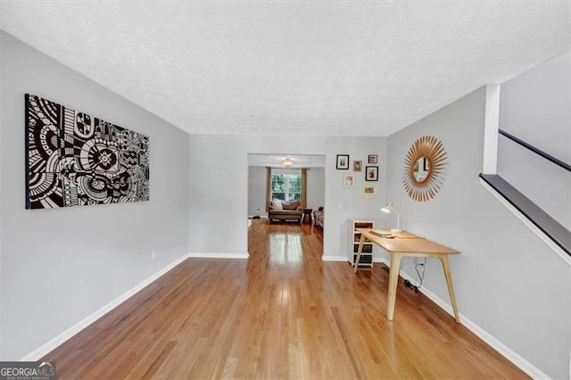 1625 Clark Lake Dr NW, Acworth, GA 30102 - hall with light wood-style flooring, a textured ceiling, and baseboards