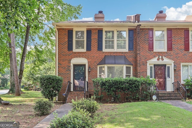 967 Chippendale Ln, Norcross, GA 30093 - view of front of house featuring a chimney, a front yard, and brick siding