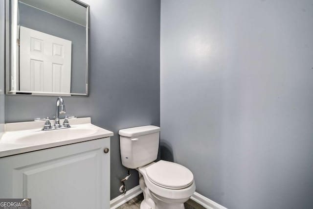 2885 Field Spring Dr, Lithonia, GA 30058 - half bath with toilet, vanity, baseboards, and wood finished floors