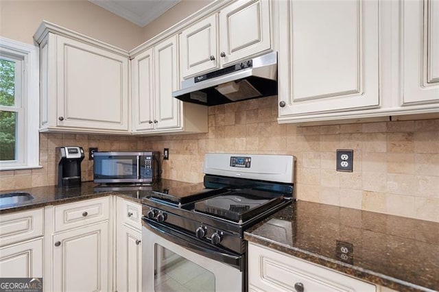 404 Pine Grove Way, Woodstock, GA 30189 - kitchen with appliances with stainless steel finishes, under cabinet range hood, backsplash, dark stone countertops, and crown molding