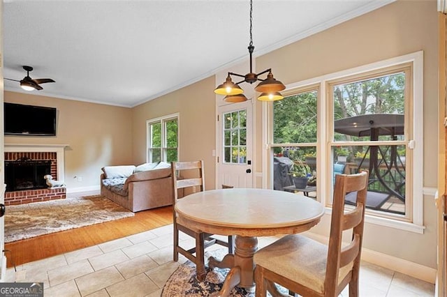 404 Pine Grove Way, Woodstock, GA 30189 - dining area with ornamental molding, light tile patterned flooring, ceiling fan, baseboards, and a fireplace