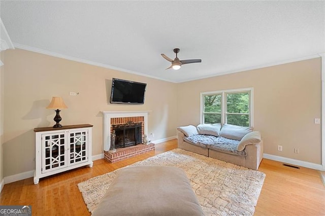 404 Pine Grove Way, Woodstock, GA 30189 - living room featuring ceiling fan, wood finished floors, ornamental molding, a fireplace, and baseboards