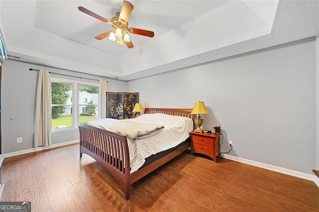 404 Pine Grove Way, Woodstock, GA 30189 - bedroom with a tray ceiling, wood finished floors, baseboards, and ceiling fan