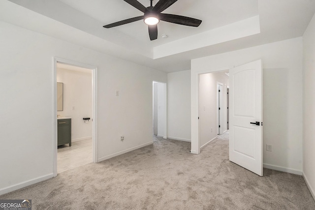 3473 Shoal Oak Ct, Riverdale, GA 30296 - unfurnished bedroom featuring light carpet, connected bathroom, a raised ceiling, and ceiling fan
