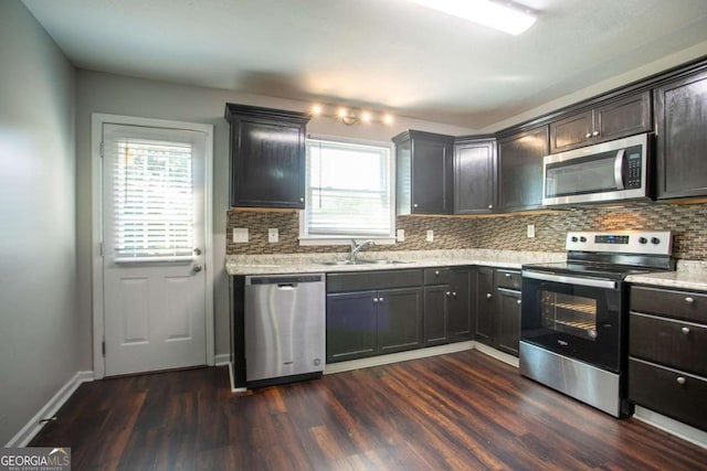 4331 Wrexham Ct, Snellville, GA 30039 - kitchen with stainless steel appliances, a sink, decorative backsplash, dark wood-style flooring, and baseboards