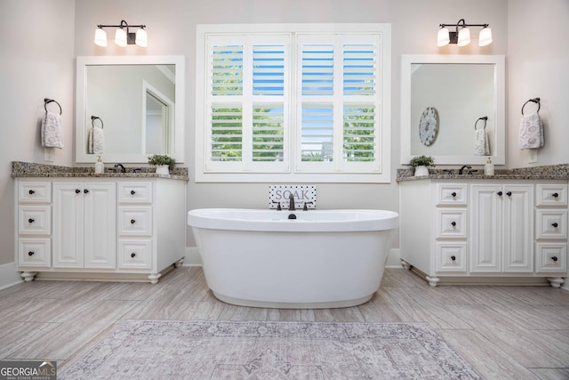 8218 Lallarook Dr, Columbus, GA 31909 - bathroom featuring wood finished floors, vanity, a freestanding tub, and baseboards
