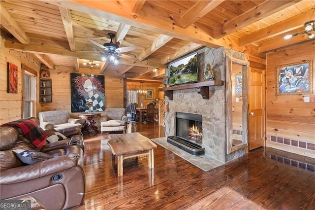 281 Wildwood Ct, Dawsonville, GA 30534 - living room featuring wooden walls, wood ceiling with exposed beams, hardwood / wood-style floors, ceiling fan, and a stone fireplace