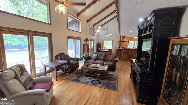396 Greenleaf Dr, Lavonia, GA 30553 - living room featuring a ceiling fan, high vaulted ceiling, light wood finished floors, beamed ceiling, and a textured ceiling