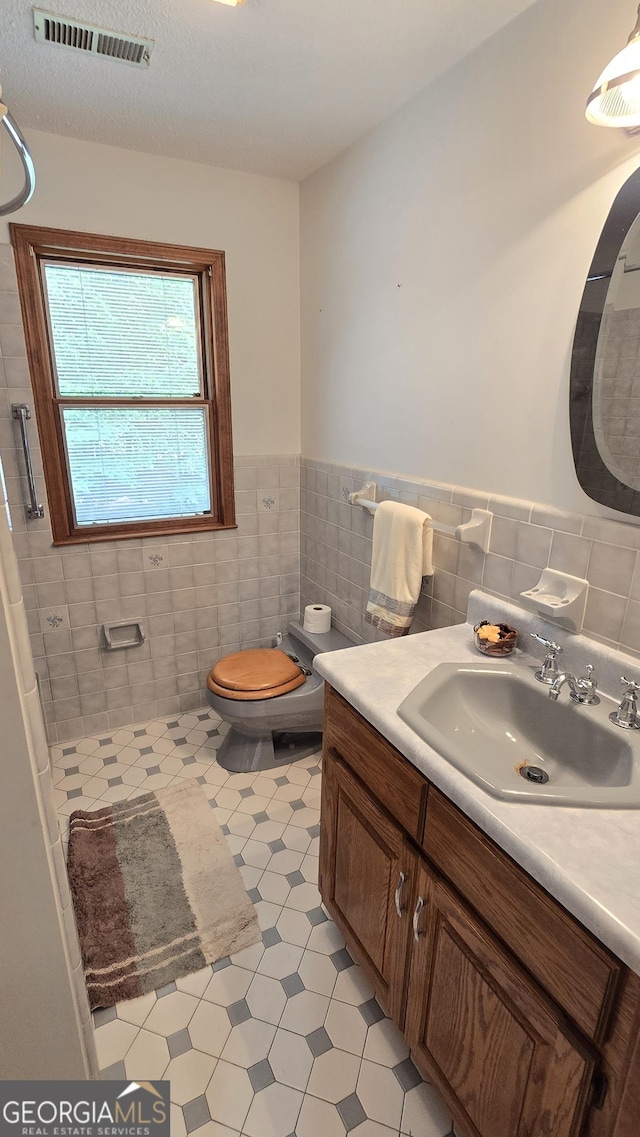 396 Greenleaf Dr, Lavonia, GA 30553 - bathroom with vanity, toilet, tile walls, a wainscoted wall, and tile patterned floors