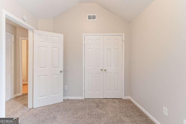 5421 Salem Springs Dr, Lithonia, GA 30038 - unfurnished bedroom with carpet floors, vaulted ceiling, and a closet