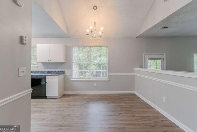 5421 Salem Springs Dr, Lithonia, GA 30038 - kitchen with black dishwasher, white cabinetry, a chandelier, light wood-style floors, and lofted ceiling